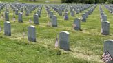 Volunteers place flags on gravesites at Missouri Veterans Cemetery