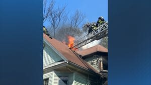 Firefighter rescued from burning roof of Dorchester home
