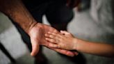 Hands in! Humans join hands to see if their dogs join in