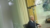 Seen through a window, US President Joe Biden speaks during an address to the nation from the Oval Office of the White House in Washington, DC on July 14, 2024.