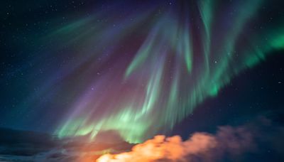 Watch an Icelandic volcano erupt below northern lights