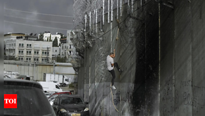 Palestinians in West Bank risk crossing Israel's separation barrier to flee failing economy - Times of India