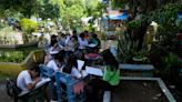 Students meet under trees as schools shelter villagers displaced by Philippine volcano