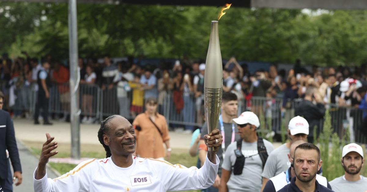 Snoop Dogg lights up Games as he carries the Olympic torch before opening ceremony in Paris