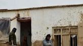 Afghans clear debris and mud from a damaged house in Laqiha village, Baghlan province following flash floods that have left hundreds of people dead in Afghanistan