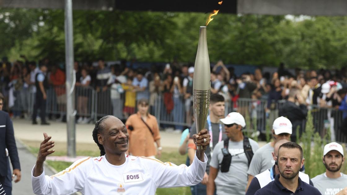 Snoop Dogg lights up Games as he carries the Olympic torch before opening ceremony in Paris