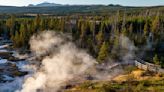 Tourist leads young children out to scalding hot springs at Yellowstone National Park