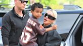 Kim Kardashian dons a baggy black outfit as she carries her son Psalm