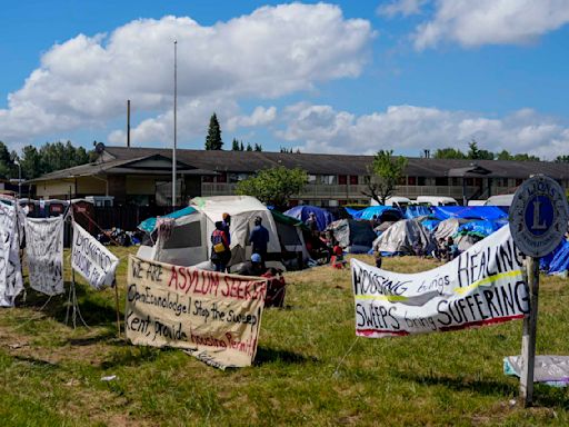 Hundreds of asylum-seekers are camped out near Seattle. There's a vacant motel next door