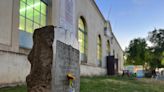 A headstone decorates lawn of an Oregon State Fairgrounds building. Why is that?