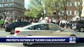 Protestors rally against Tucker Carlson's appearance at the 'Remember America Speaker Series'