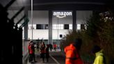 Amazon workers walk out in UK first for company’s staff in pay dispute