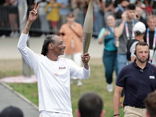 Snoop Dogg carries the Olympic torch before opening ceremony in Paris