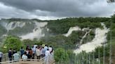 Tourists watch river Cauvery at Bharachukki falls in south Karnataka