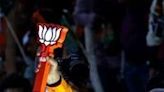 India's Prime Minister Narendra Modi (R) greets his supporters in a roadshow on May 13 during ongoing India's general election