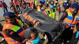 Rescuers carry body of Rohingya refugee recovered at sea after boat capsized off the coast near Calang