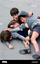 Four school boys outside in playground enjoying play fighting fun Stock ...