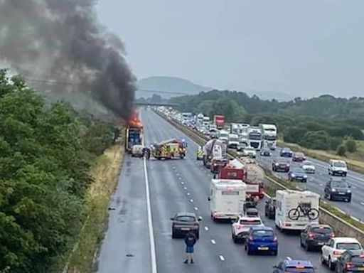 Busy motorway CLOSED after lorry carrying fairground ride bursts into flames