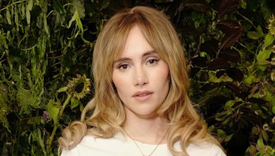 Suki Waterhouse cuts a causal figure in a pair of pin striped trousers