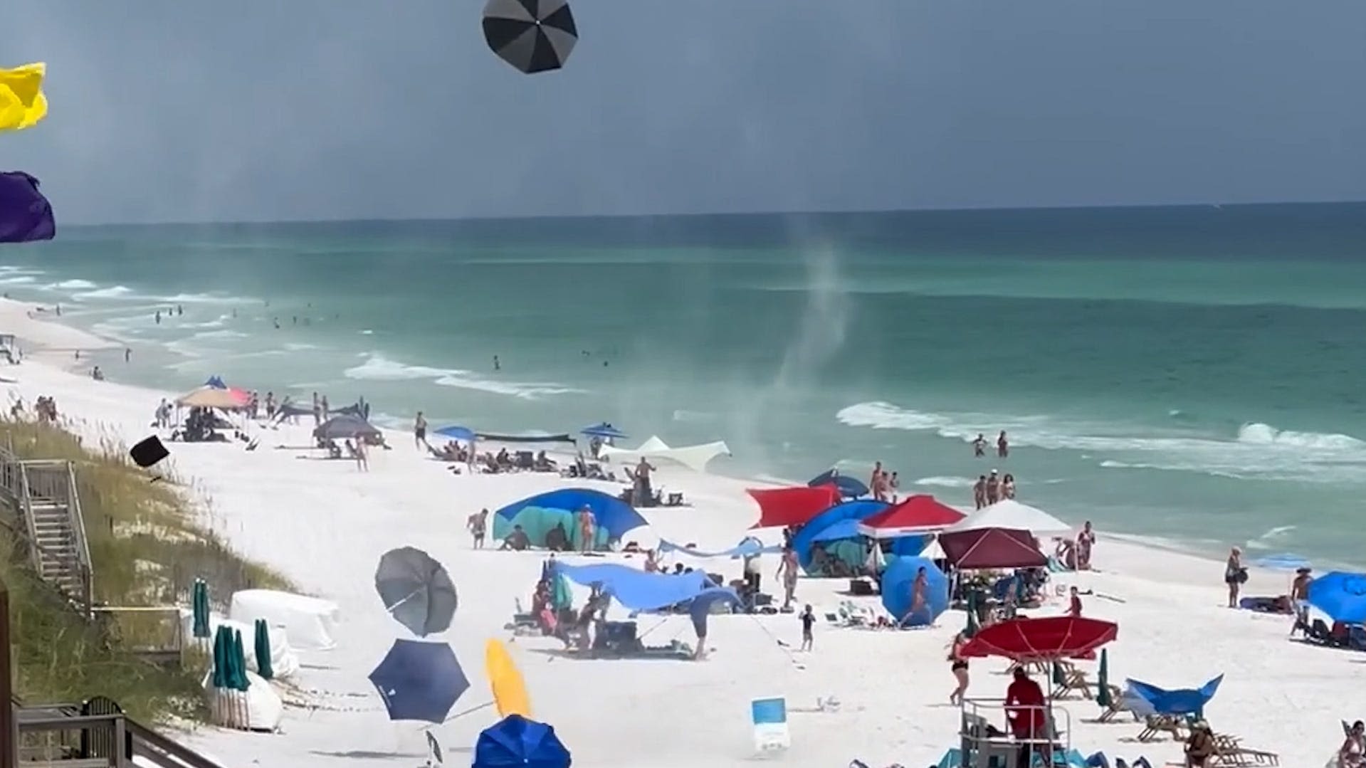 'Chaotic' scene as dust devil takes umbrellas up in a flurry on beach