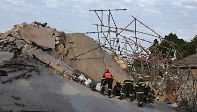 Rescuers bring out survivors from the rubble a day after a deadly building collapse in South Africa