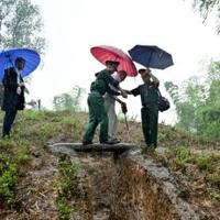 French Dien Bien Phu veteran Jean-Yves Guinard walks across an old trench with the help of Vietnamese soldiers at Him Lam hill ahead the 70th anniversary of the decisive battle