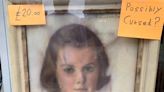 A creepy portrait at a UK charity shop went viral for being 'possibly cursed.' But the shop manager says 'nothing evil happened here' and wants people to stop calling him.