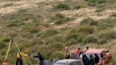 Rescuers are seen working at a clifftop shaft where bodies believed to be those of three missing surfers were discovered