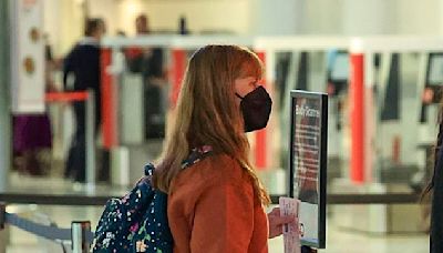 Terri Irwin carries Mickey Mouse luggage through the airport