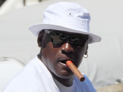 Michael Jordan puffs on a cigar while he and his wife enjoy a stroll
