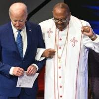 US President Joe Biden (L) stands with Bishop Ernest Morris Sr during a church service and campaign event at Mount Airy Church of God in Christ in Philadelphia...