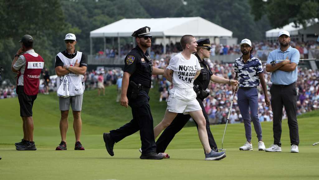 Six climate protesters run onto 18th green and spray powder, delaying finish of PGA Tour event