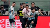 Lionel Messi scores, gets hugged by a fan during Argentina's 2-0 win over Australia