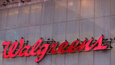 Walgreens cuts profit view, to shut more stores on spending hit