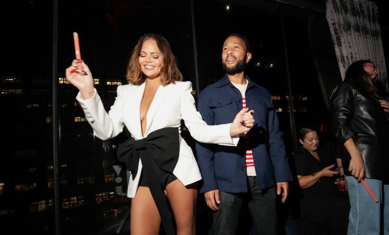 Chrissy Teigen Puts Coquette Spin on Suiting in White Blazer Featuring Statement Bow for JBL Fest 2024 With John Legend