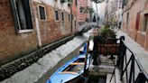 Historic venice canals reduced to muddy ditches by severe low tides