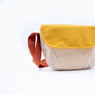 A bag worn across the body with a belt or strap. Popular for travel and everyday use. Can be worn on the front or back of the body. Often has a single compartment with a zipper or flap closure.