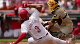 Kyle Higashioka of the San Diego Padres tags out Jeimer Candelario of the Cincinnati Reds at home plate in the first inning at Great American...