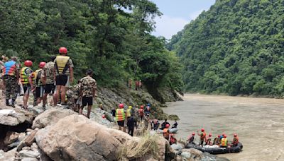 Rescuers recover first body from 2 buses that were hit by landslide and fell into a river in Nepal