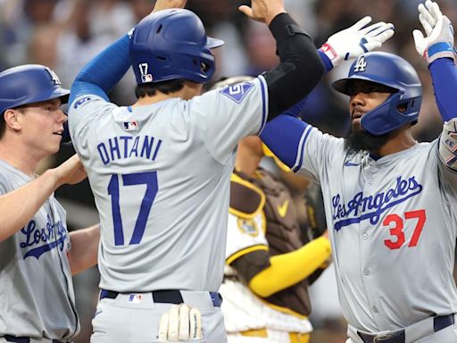 The Los Angeles Dodgers' Will Smith, left, and Shohei Ohtani congratulate Teoscar Hernandez after his grand slam during the sixth inning against the San Diego Padres...