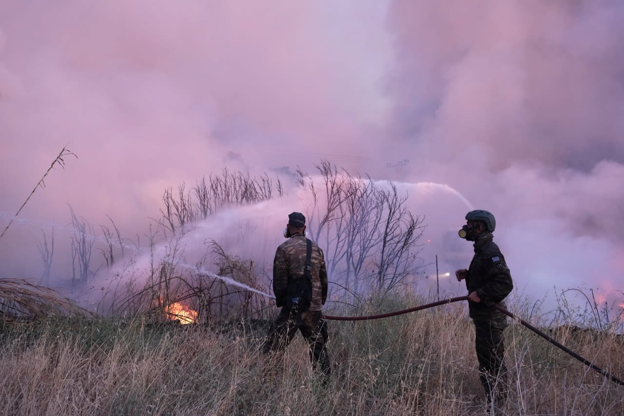 Crews battle scattered fires in Athens suburbs, helped by calmer winds and reinforcements