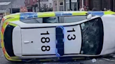 Angry mob smash police car up and torch bus as riot chaos caught on camera