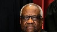 Associate Justice Clarence Thomas sits during a group photo of the Justices at the Supreme Court in Washington, DC in 2021