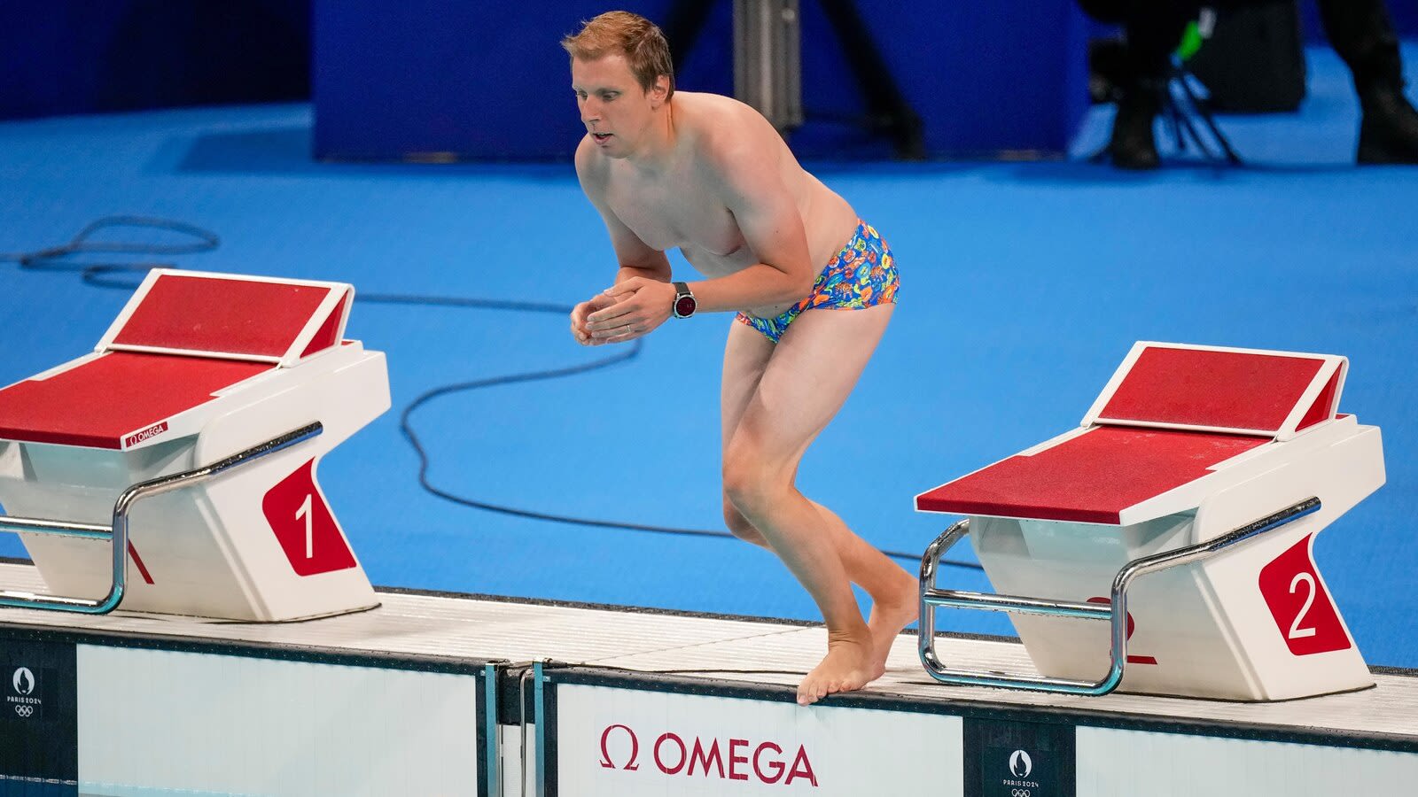 Pool worker strips to his briefs to retrieve a lost swim cap, drawing whistles from fans