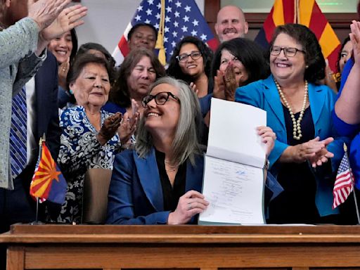 Arizona's Democratic governor signs a bill to repeal 1864 ban on most abortions