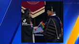 SPU grads protest anti-LGBTQ+ policy by handing Pride flags to university president at graduation