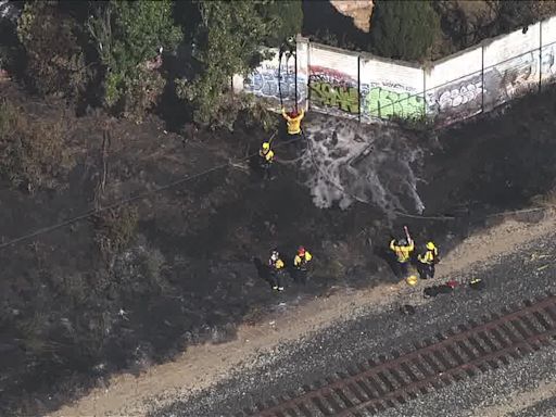 Grass fire burning by train tracks damages home in Fremont