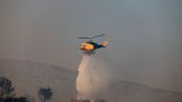 Bomberos griegos combaten un nuevo incendio forestal cerca de Atenas en medio de fuertes vientos