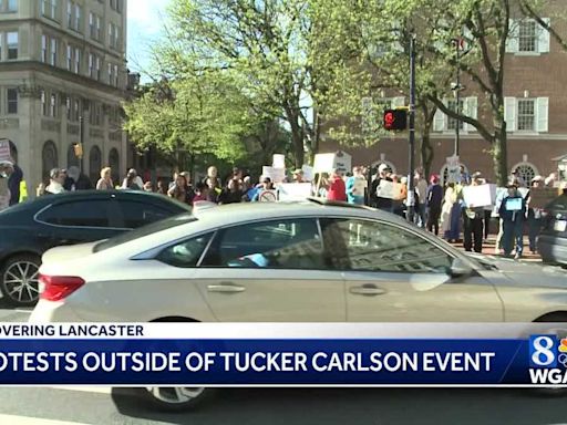 Protestors rally against Tucker Carlson's appearance at the 'Remember America Speaker Series'