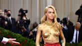 Cara Delevingne paints breasts gold for Met Gala